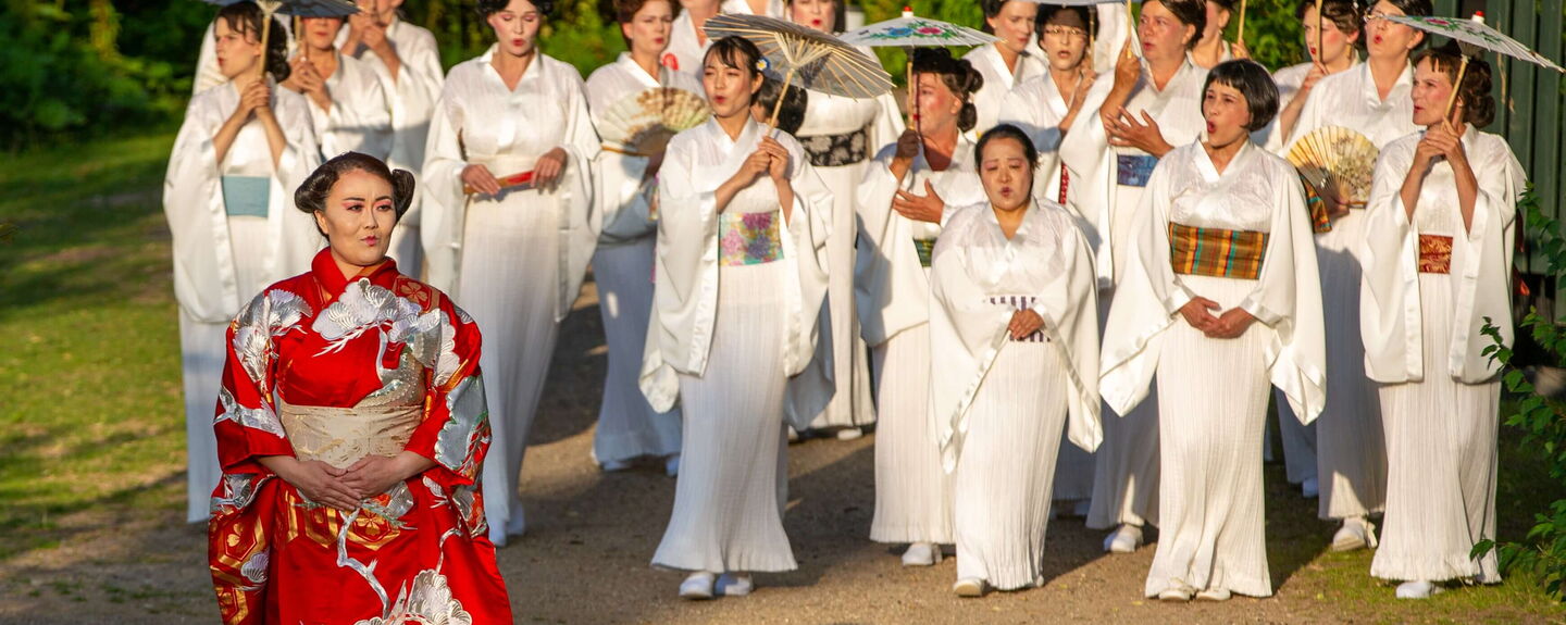 Yitian Luan (Foto) und Tetiana Miyus wechseln sich in der Rolle von Cio-Cio-San ab. Zudem zu sehen: Der Chor der Eutiner Festspiele. Foto: EFS