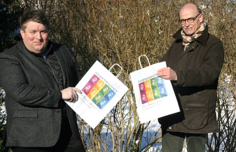 Falk Herzog und Hans-Wilhelm Hagen (WVE) präsentieren die mit Webers Portrait bedruckten Eutiner Einkaufstaschen
